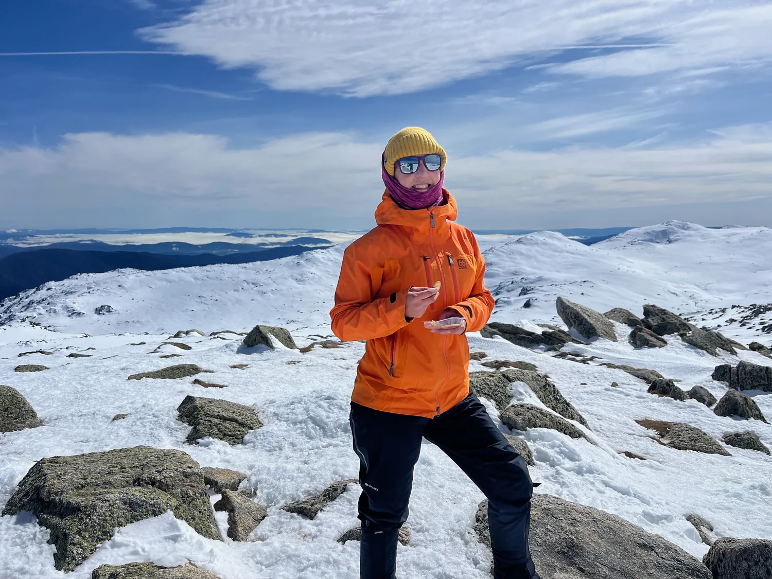 MC in an orange jacket on a snow-covered summit